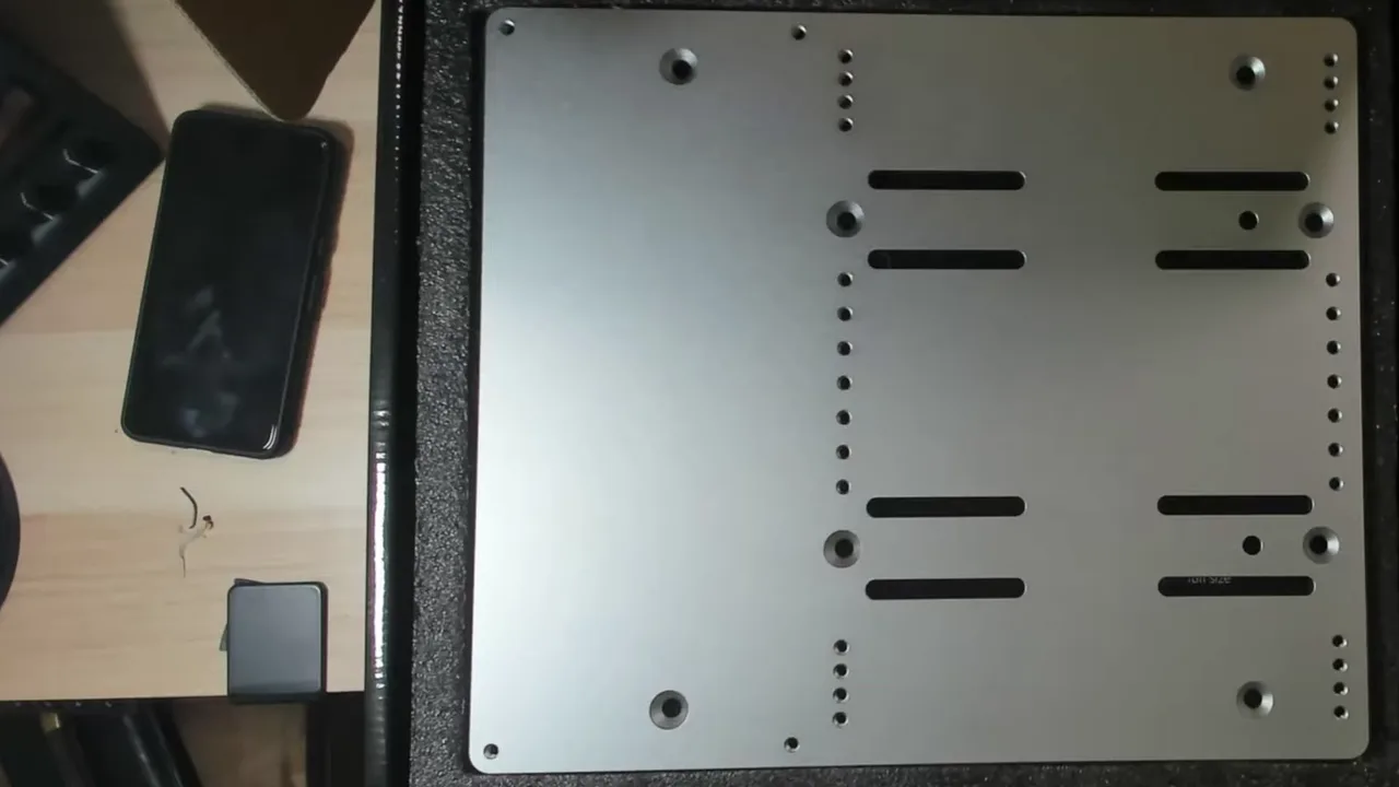 Une plaque tout en métal, percée de partout. J'avais regardé les dimensions avant de l'ouvrir : c'est du standard, elle se fixera sans problème.