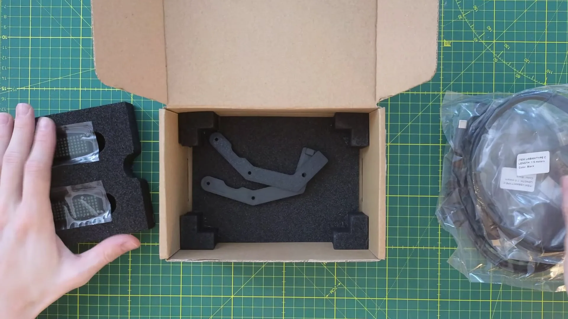 Au fond de la boîte, les deux supports pour profilé aluminium. À droite, les deux câbles USB de 1,5 m : un par afficheur.