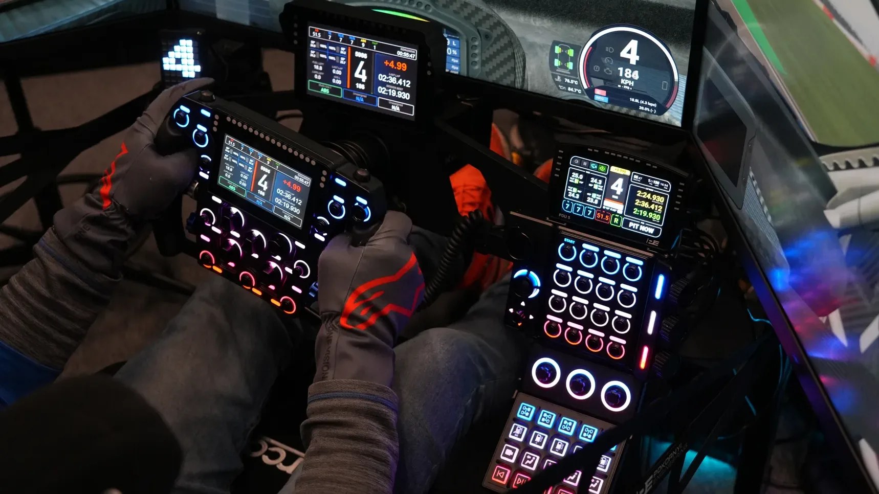 Le simulateur de démonstration de Pokornyi Engineering, avec son volant et une colonne de boîtiers de la marque à portée de main.