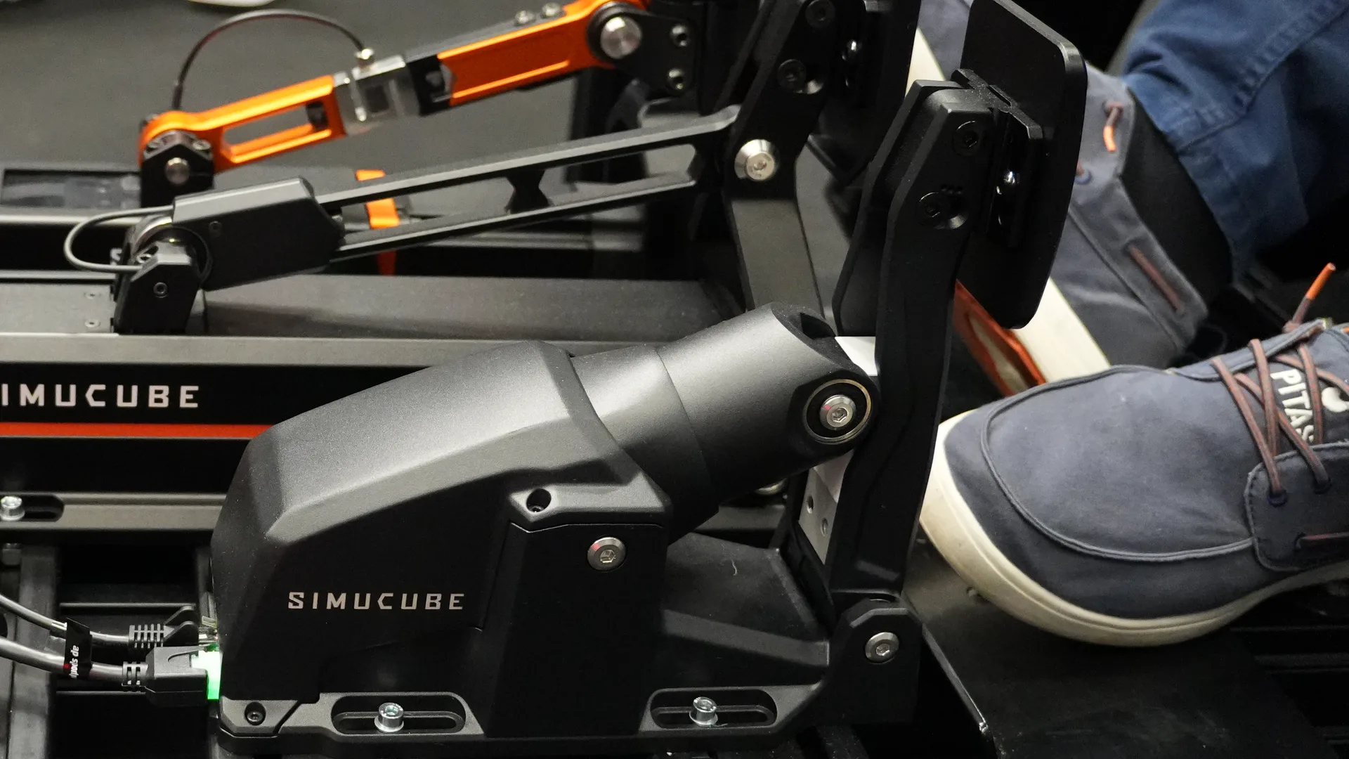 L'ActivePedal Sport sur un rig du stand Simucube : boîtier court et incliné, comme sur le visuel officiel. C'est ce modèle que j'ai essayé au frein, à 75 kg.