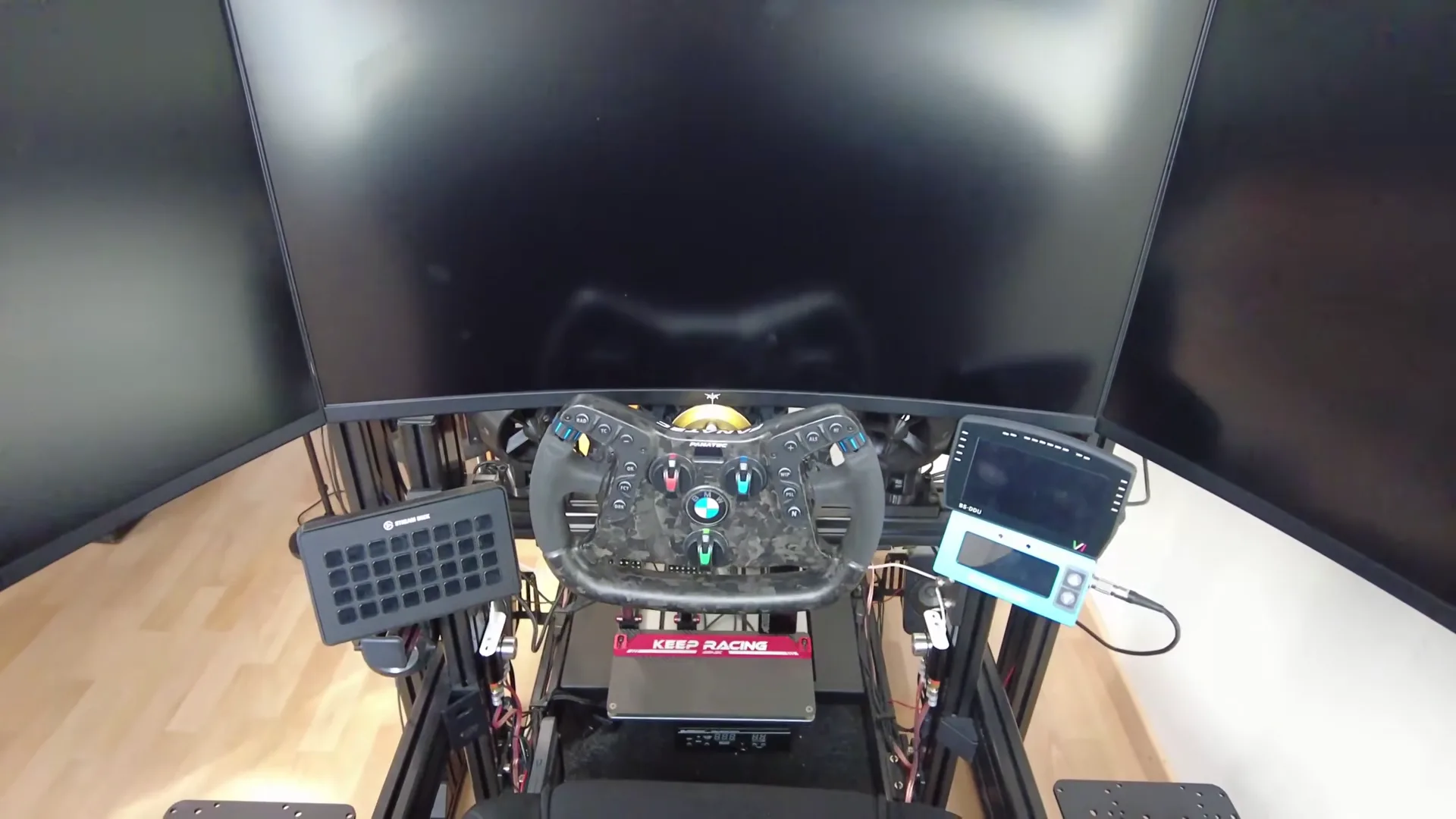 Trois écrans à la place de l'ultrawide, et la base quasiment sous l'écran : le volant se retrouve presque dans l'image. Le dashboard, lui, a dû passer sur le côté.