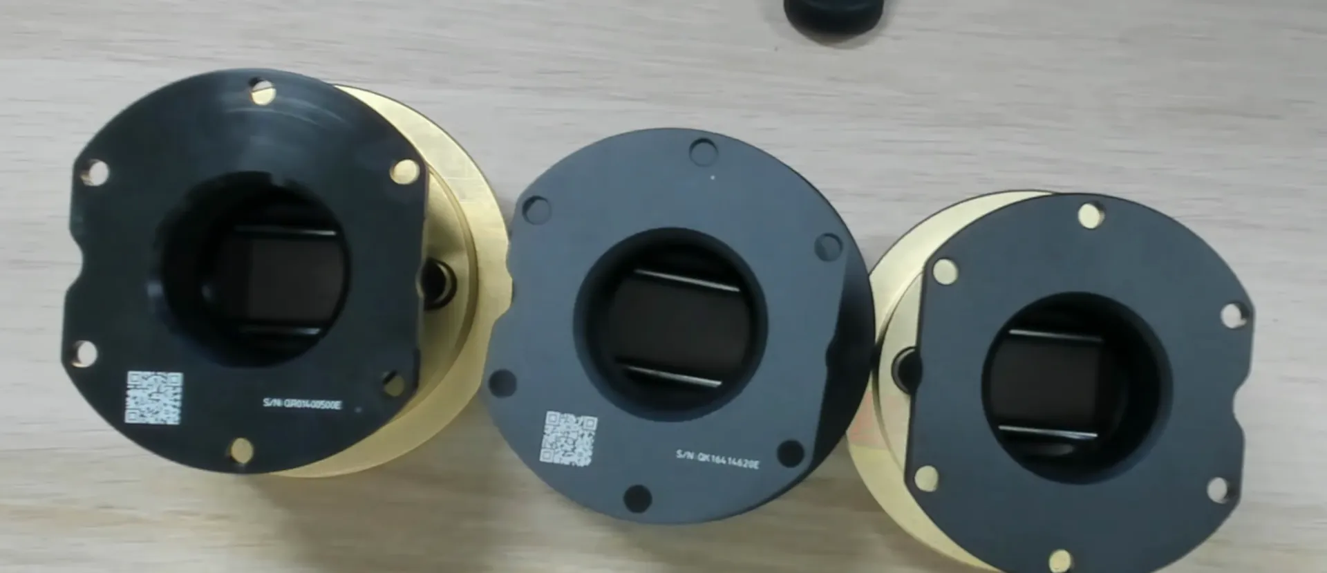 Sous le QR, un QR code et un numéro gravés sur le QR2 Pro et le QR2 de Fanatec, à gauche et au centre. Rien sur le Simube, à droite.