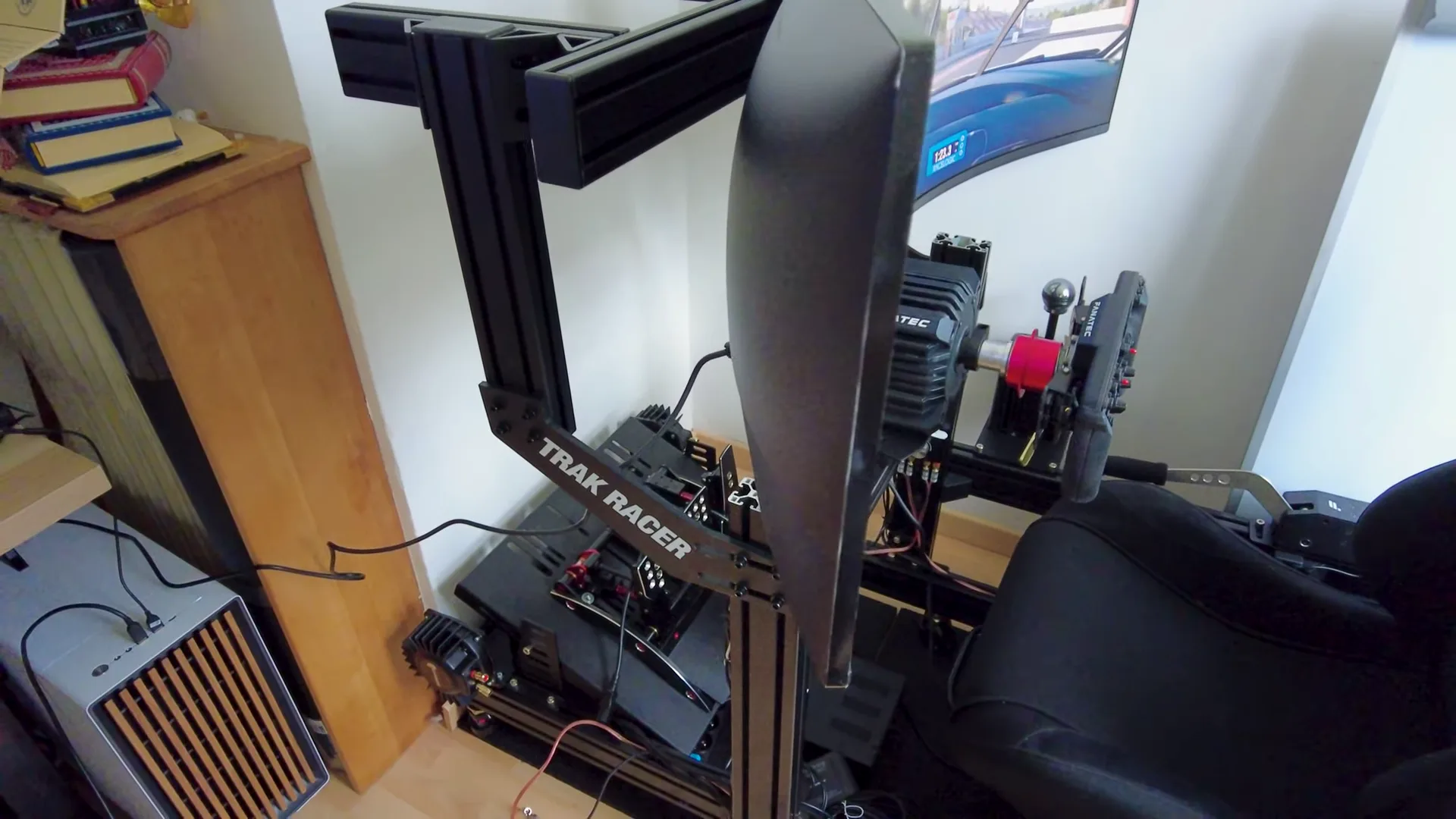 De profil, sur son support Trak Racer : la courbure ramène les bords de l'écran vers le siège.