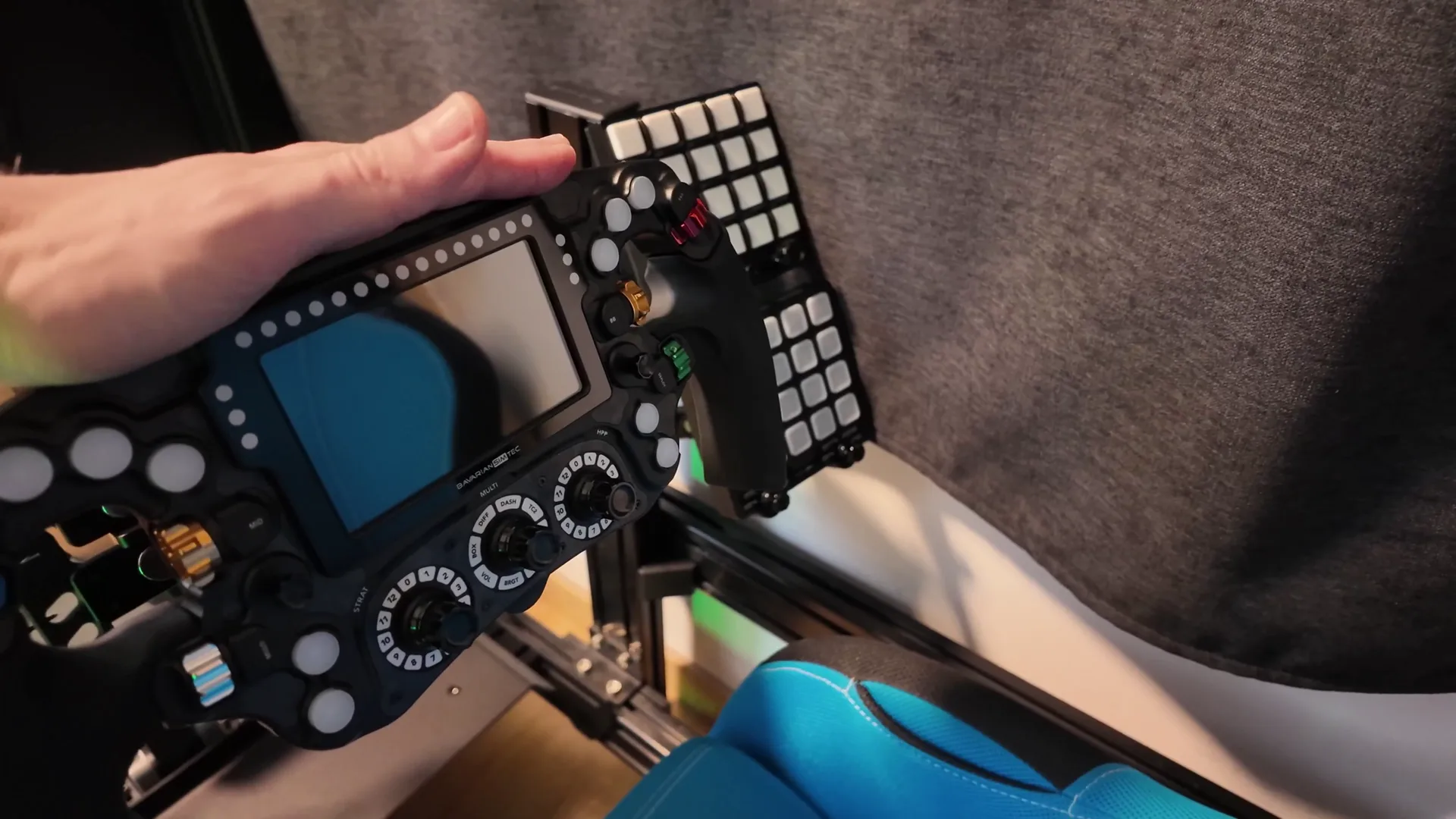 L'OmegaPRO V2 de BavarianSimTec, sur le châssis de test au moment de la vidéo, devant les deux boîtes à boutons.