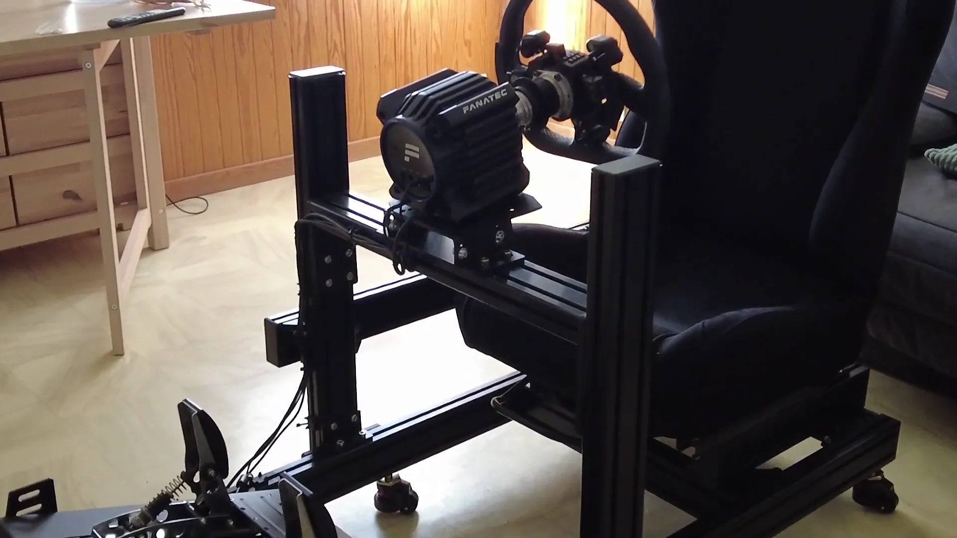 Mon tout premier setup, coincé dans le salon : la GT DD Pro sur le châssis GT Omega, monté sur roulettes. En bas, les CSL Pedals et leurs ressorts ajoutés.
