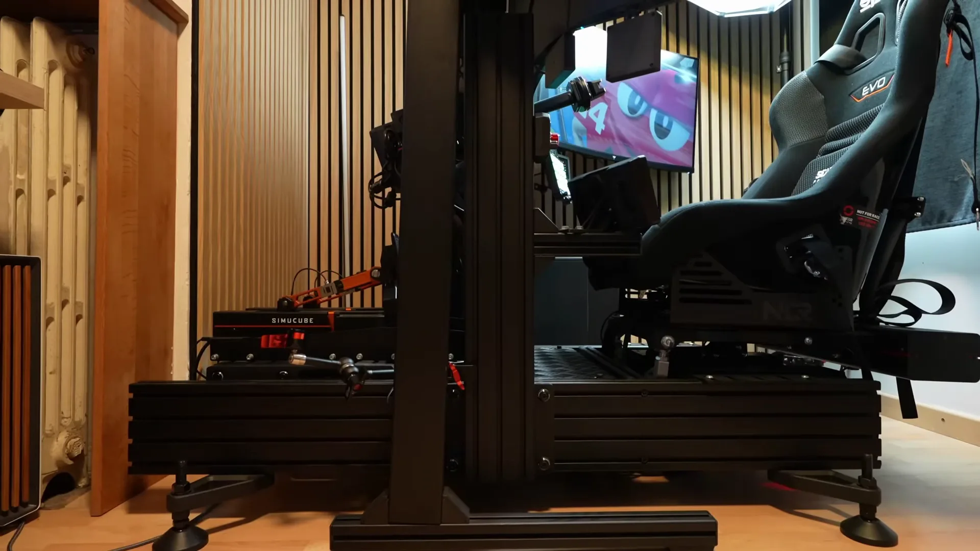 Août 2026, même angle : le baquet est maintenant posé sur le seat mover de Qubic System, avec des supports Next Level Racing plus longs.