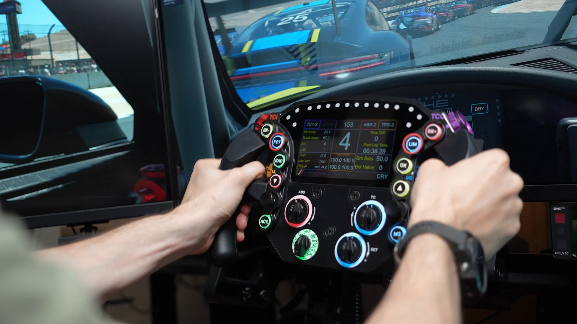 Les deux mains sur le volant en course, l'écran affiche la télémétrie et le rapport engagé